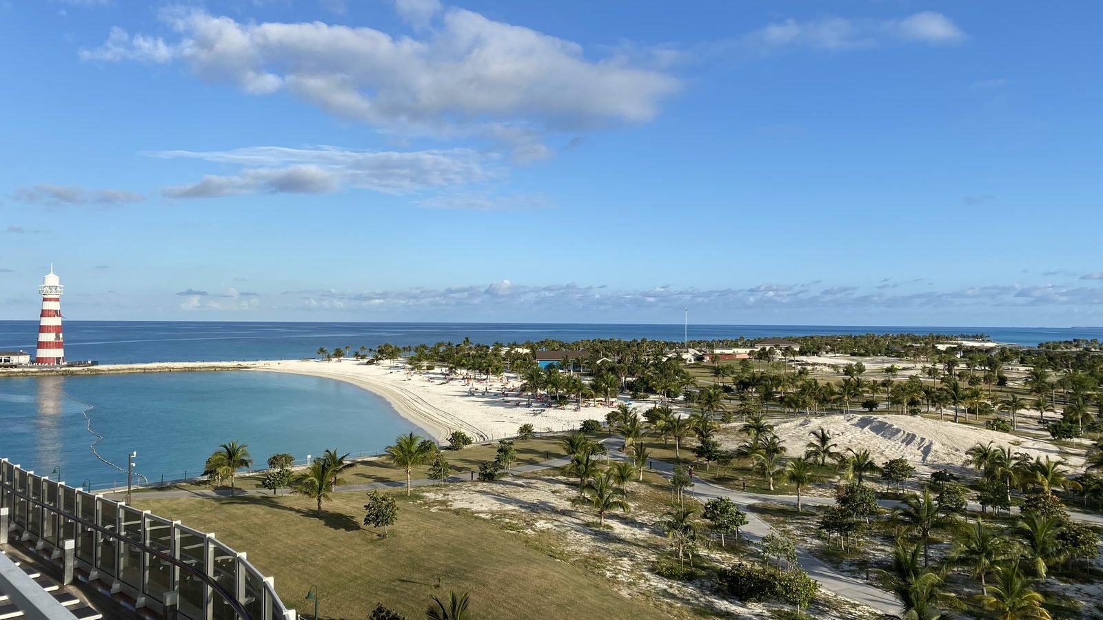 View from a ship's deck of the beach and red and white lighthouse at MSC Ocean Cay in the Bahamas
